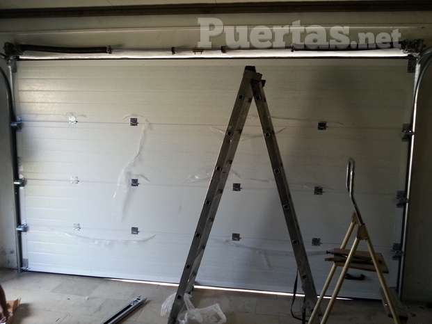 Instalación a medida de puerta seccional acanalada color blanco